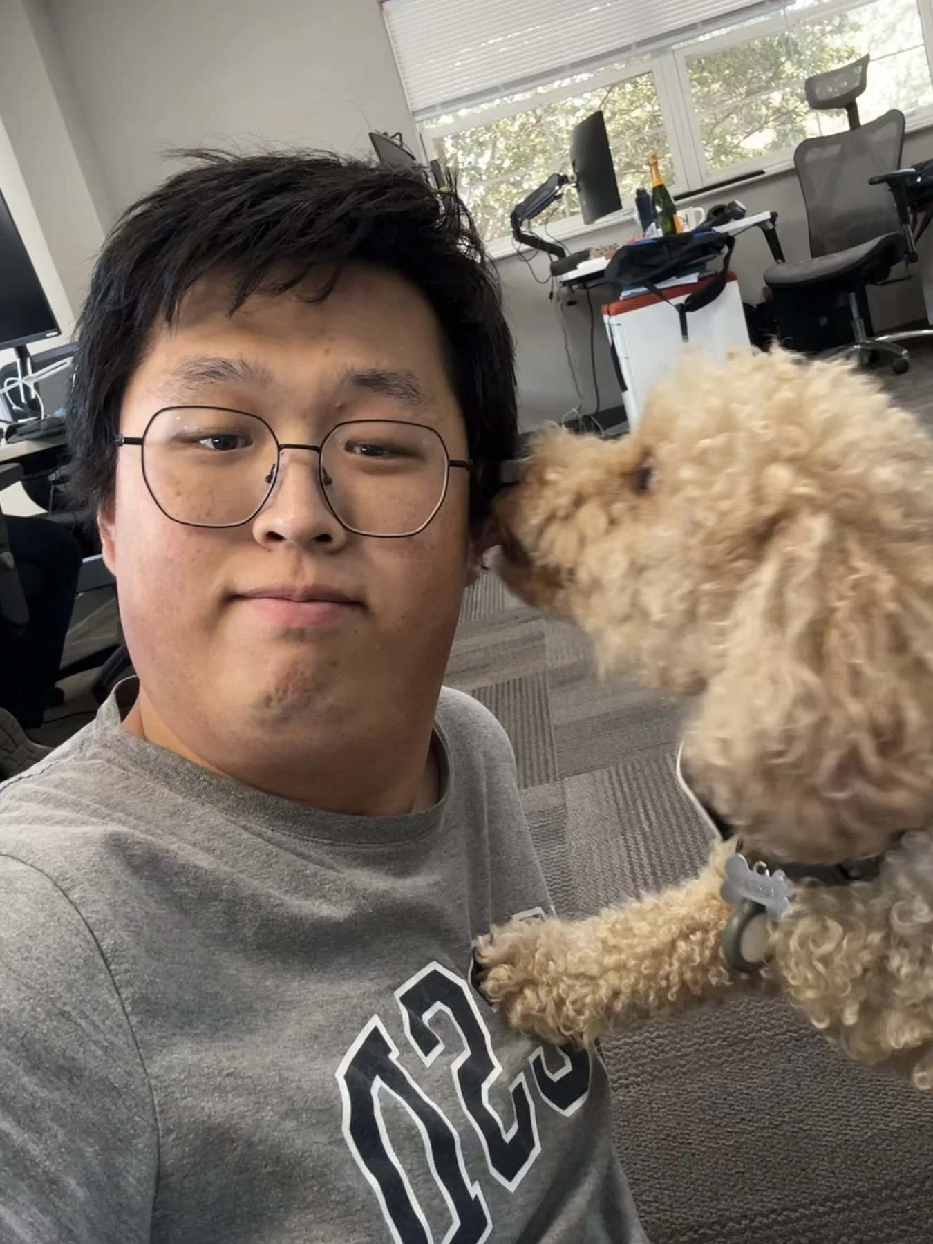 Hejia sitting beside a small curly-haired dog