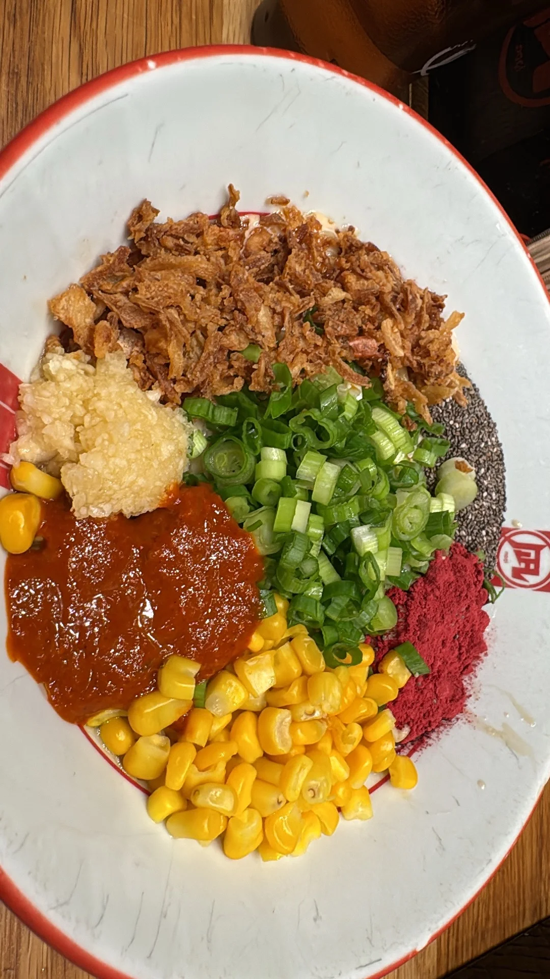 Rice bowl topped with beef, corn, green onions, and sauces